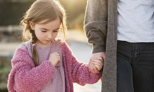 Petite fille qui tient la main d'un adulte