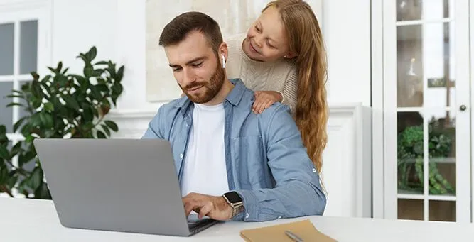 Papa qui travaille avec sa fille à côté