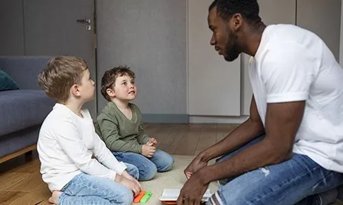 Un parent qui discute avec deux enfants